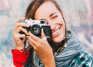 Teen girl with braces holding camera